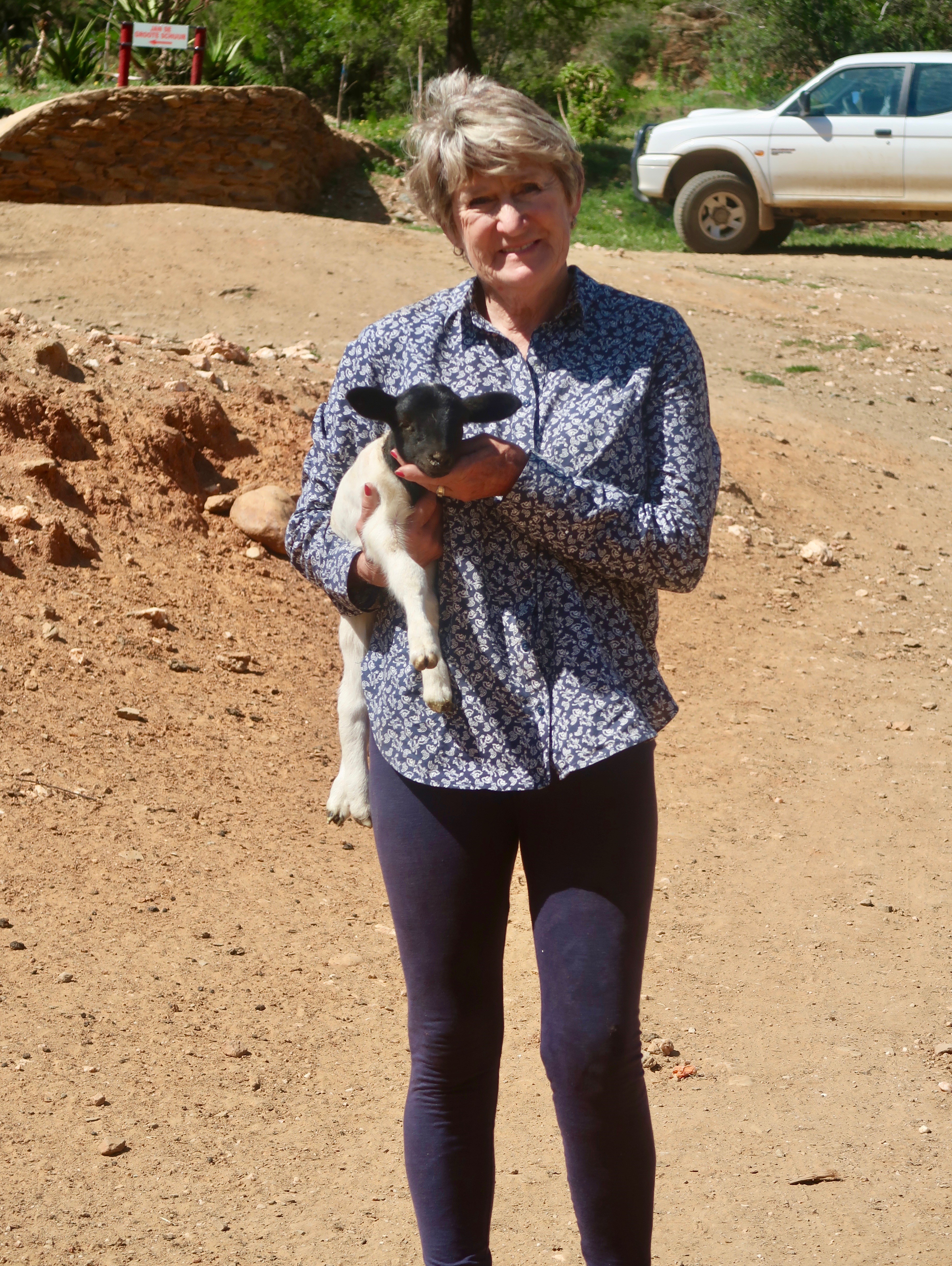 Maggie Fourie holding a lamb on the Oudemagurie farm