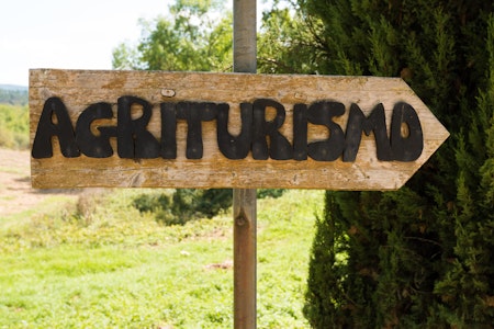 Handmade wooden agriturismo sign in Tuscany – agritourism is a typical concept of bed and breakfast in a farming environment in Italy.