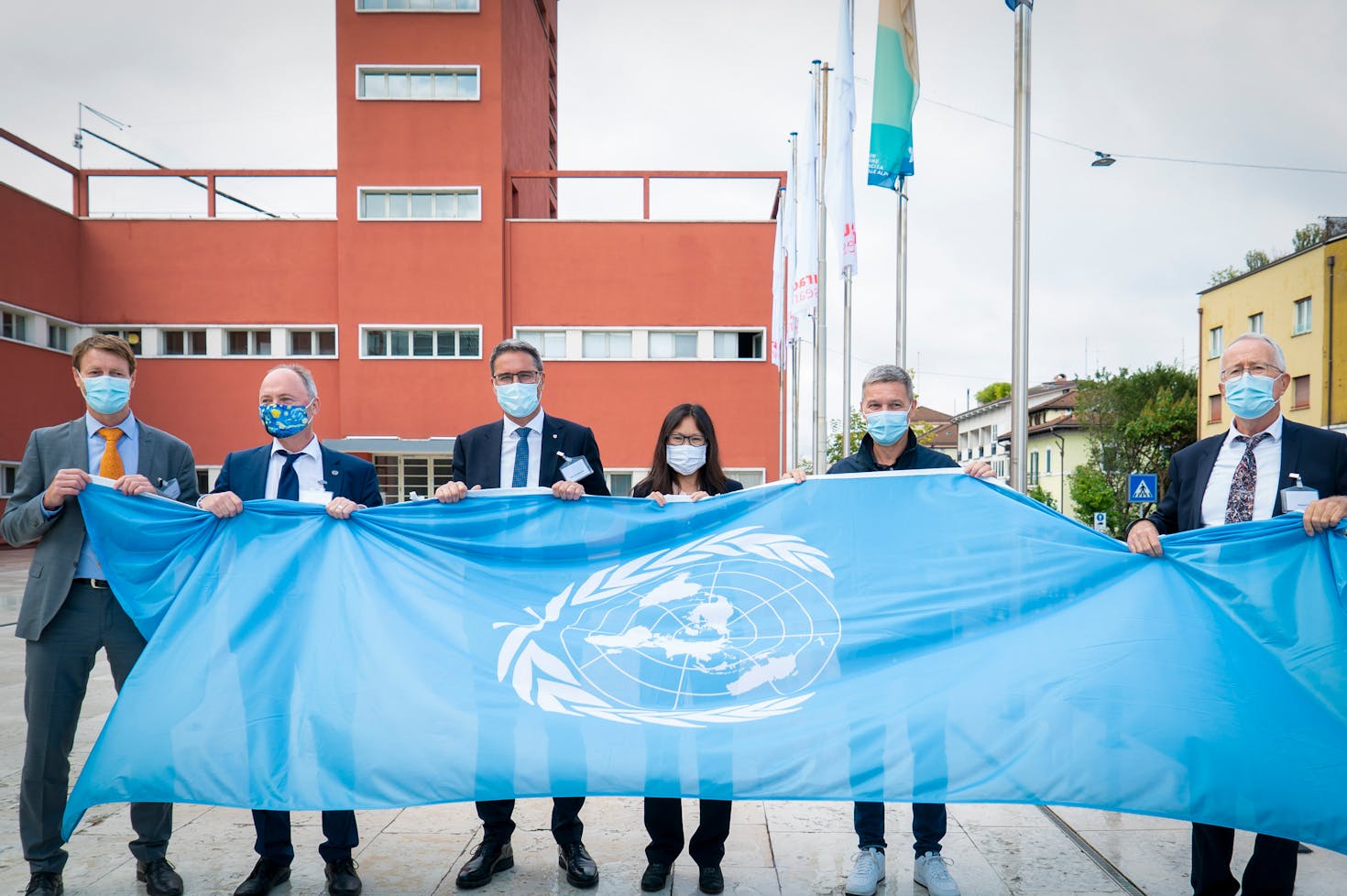 this picture shows the UN flag raising that took place on September 25th, 2020. The event marked the official establishment of the United Nations duty station in Bolzano, where the center Global Mountain Safeguard Research (GLOMOS) is jointly run by UNU-EHS and Eurac Research. Present to the event were (from left to right): GLOMOS directors Stefan Schneiderbauer and Joerg Szarzynski, South Tyrol governor Arno Kompatscher, UNU Vice-Rector for Europe and UNU-EHS’ Director Shen Xiaomeng, Eurac Research President Roland Psenner and Director Stephan Ortner.