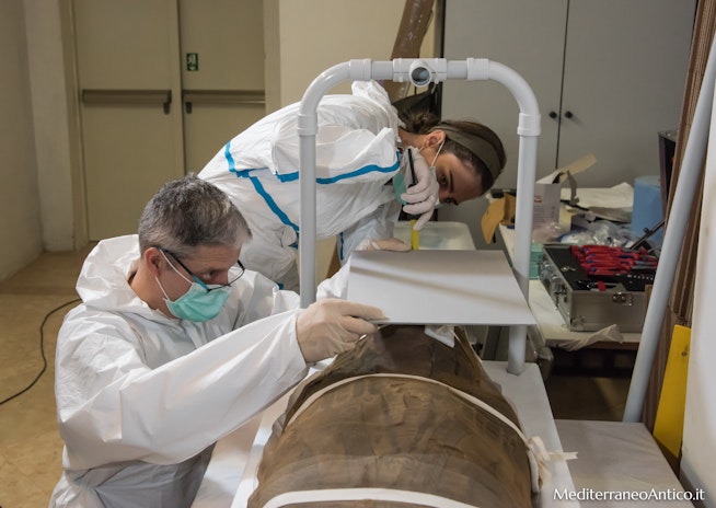 Ricercatori al lavoro mentre adattano il Conservation Soft Box alla mummia